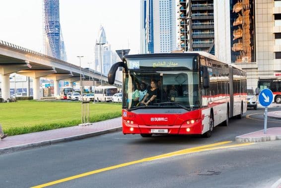 Ônibus de Dubai e arranha-céu moderno ao longo da Sheikh Zayed Road.