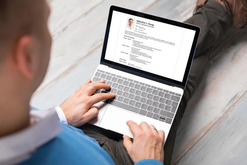 Uma pessoa escrevendo seu currículo em um laptop.