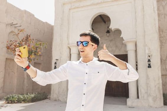 Homem gravando um vídeo blog no antigo distrito de Bur Dubai Creek.