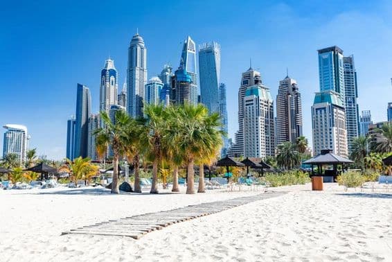 Praia de Jumeirah em Dubai com arranha-céus do porto nos Emirados Árabes Unidos.