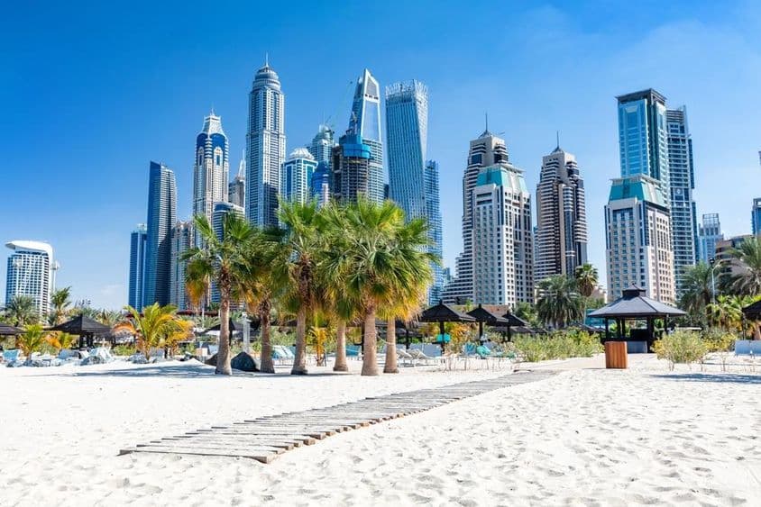 Praia de Jumeirah em Dubai com arranha-céus do porto nos Emirados Árabes Unidos.