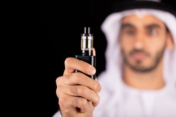 Homem árabe com um cigarro eletrônico.
