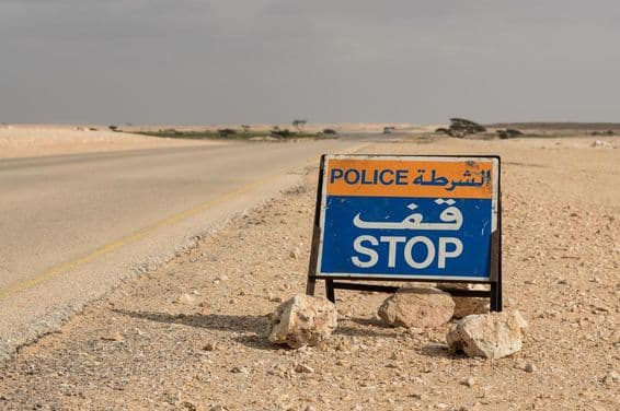 Sinal de parada policial em estrada no deserto.