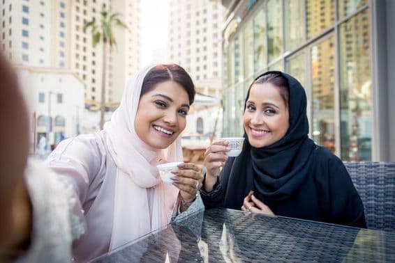 Mulheres árabes aproveitando café ao ar livre em Dubai.