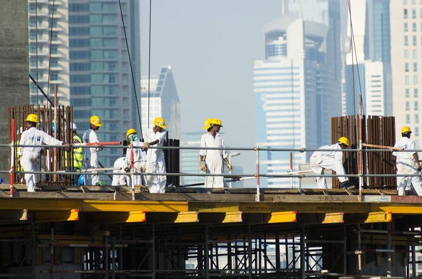 Trabalhadores sul-asiáticos trabalhando no mercado imobiliário em Dubai.