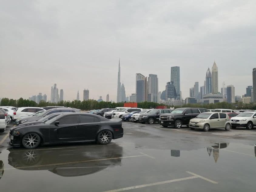 Efeito da chuva em uma área de estacionamento perto do Centro de Comércio Mundial de Dubai e Burj Khalifa.