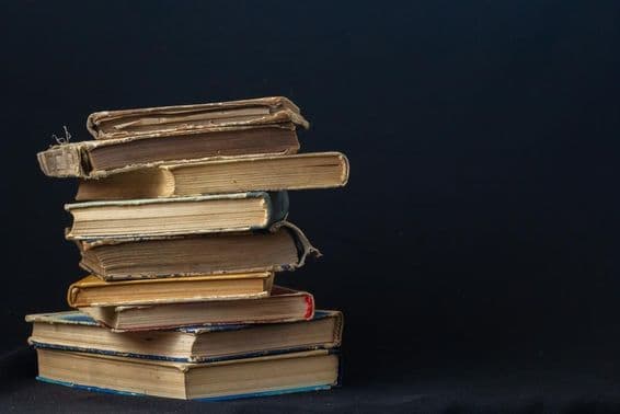 Uma pilha de livros antigos de capa dura.