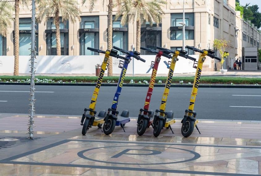 Imagem de patinetes elétricos laranja em Dubai.
