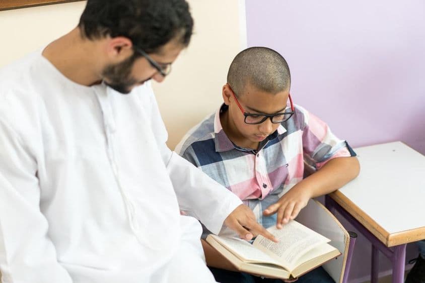 Professora jovem árabe estudando com um aluno.