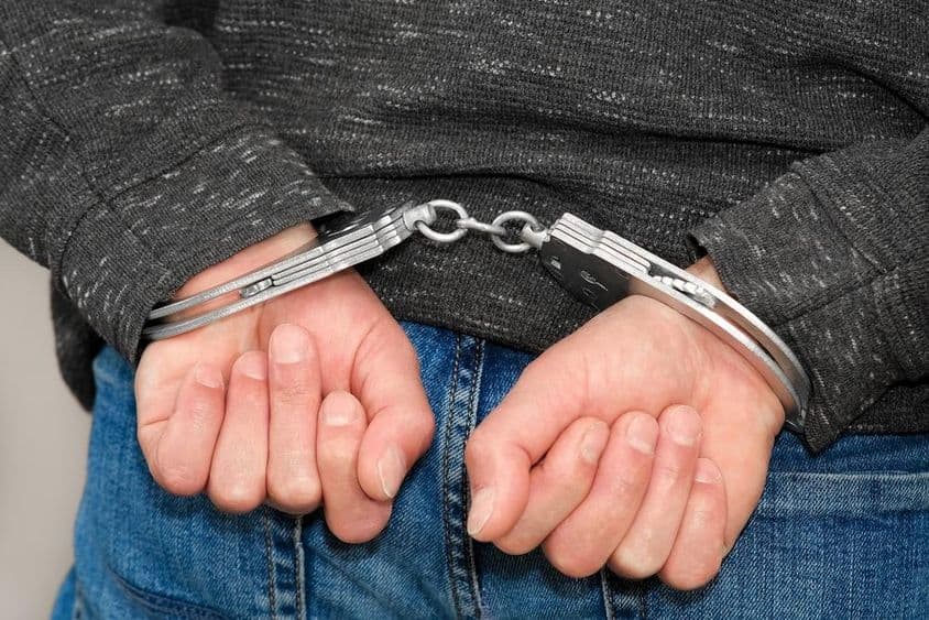 Um criminoso algemado detido por crimes.