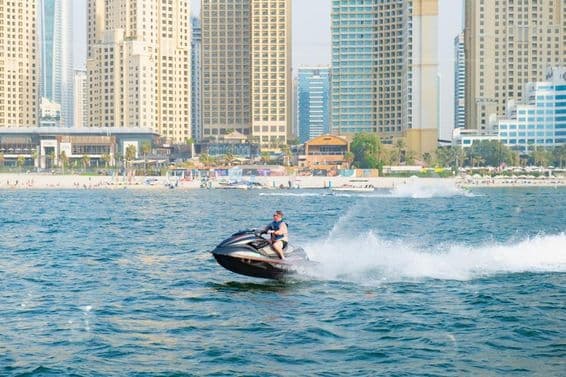 Homem andando de jet ski na Baía Marina de Dubai.