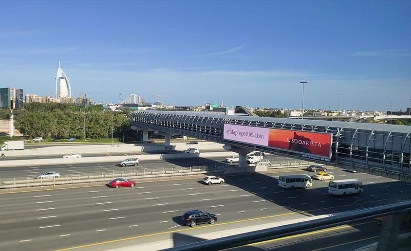 Estrada em Dubai, grande outdoor ao lado da estrada.