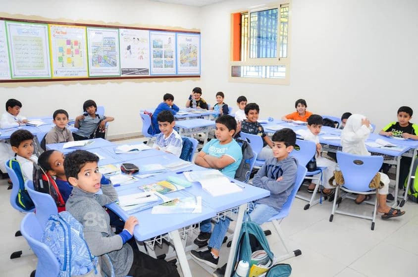 Uma sala de aula com um grupo de estudantes árabes aprendendo.