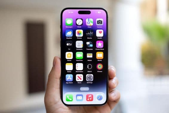 Homem segurando um iPhone 15 Pro Max com iOS 17 na tela.