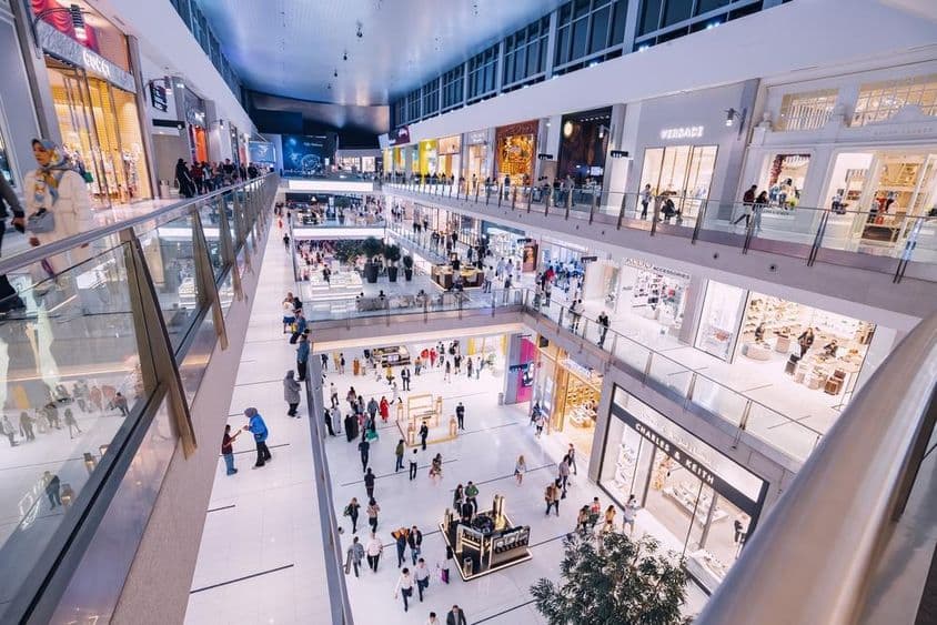 Vista interna do Dubai Mall com várias lojas e visitantes.