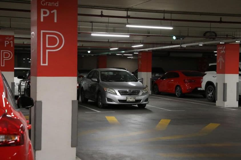Garagem moderna subterrânea em Dubai com diversos carros.