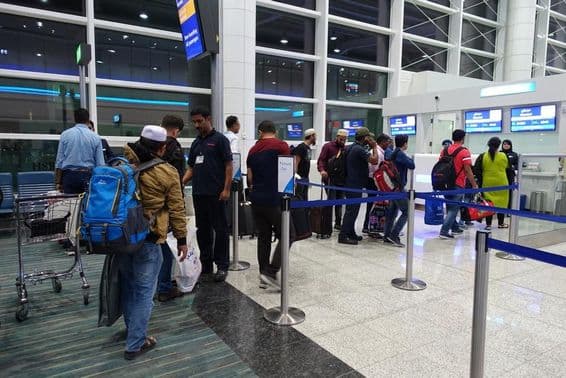 Pessoas em fila para embarque no portão do Aeroporto Internacional de Dubai.