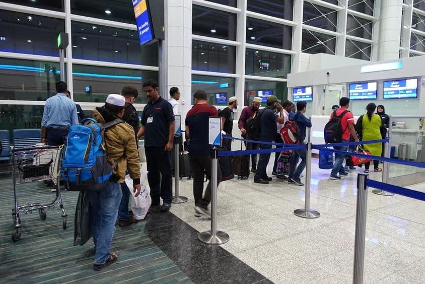 Pessoas em fila para embarque no portão do Aeroporto Internacional de Dubai.