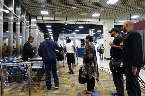 Passageiros aéreos passando por verificações de segurança no Aeroporto Internacional de Dubai.