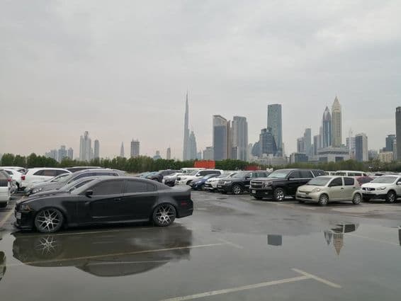 Após chuva intensa, água da chuva se acumula no solo em uma área de estacionamento de um país desértico.