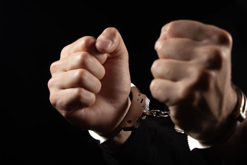 Homens algemados presos por crimes.