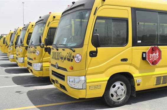 Vários ônibus escolares amarelos alinhados em um estacionamento em Dubai.