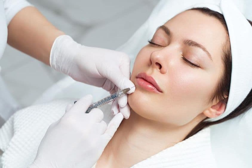 Procedimento de aumento e correção labial em um salão estético.