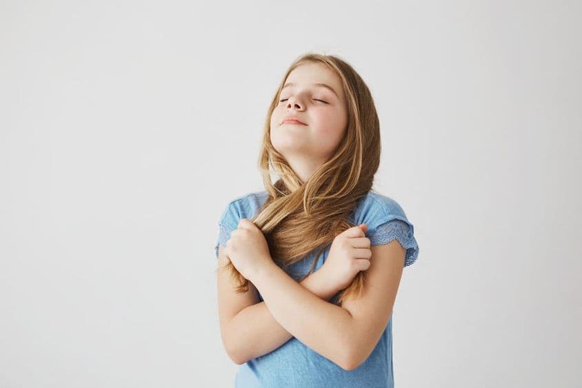 Linda menina loira respira profundamente ar fresco.