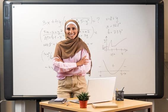 Professora árabe de hijab em sala de aula.