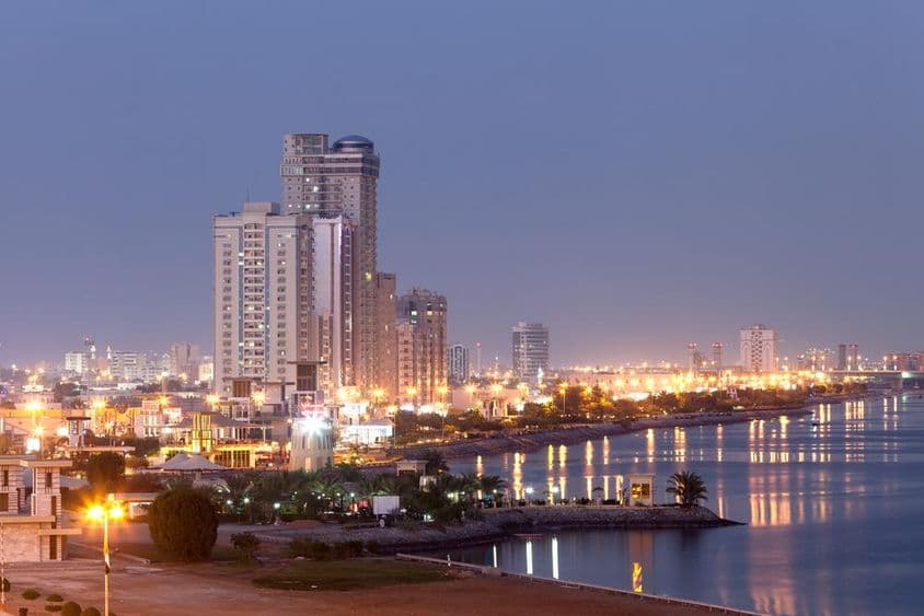 Calçadão de Ras al-Khaimah iluminado ao anoitecer.
