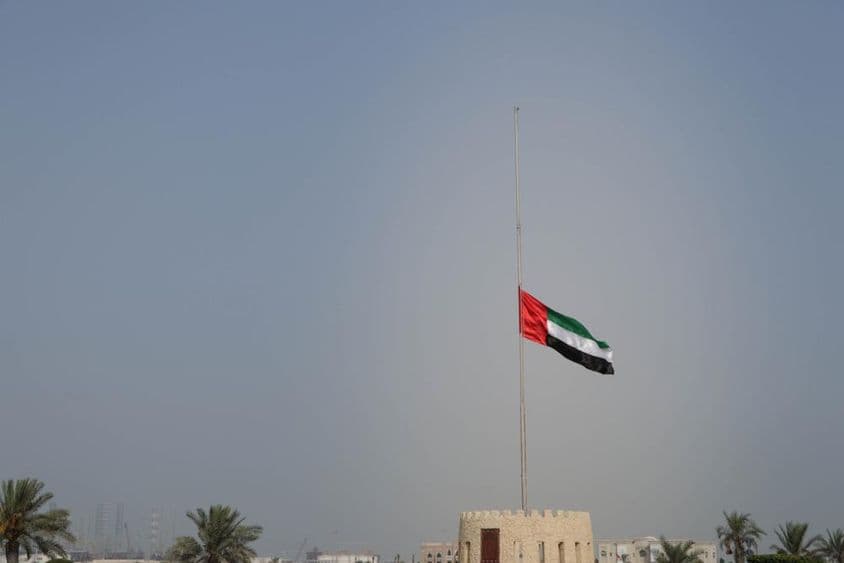 Bandeira dos Emirados Árabes Unidos hasteada a meio mastro em Sharjah.