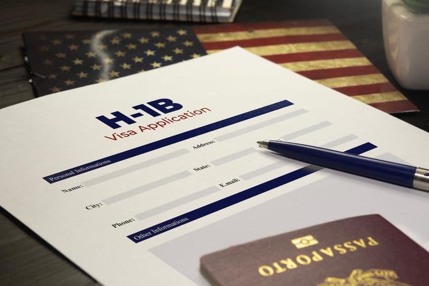 Solicitação de visto H-1B dos EUA sobre a mesa com um passaporte.