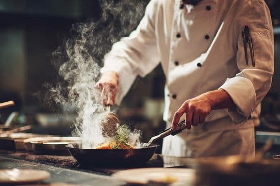 Um chef cozinhando na cozinha.
