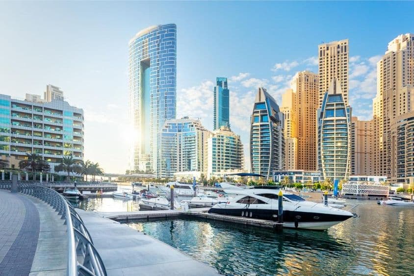 Uma vista deslumbrante da Marina de Dubai com edifícios modernos e iates na água.