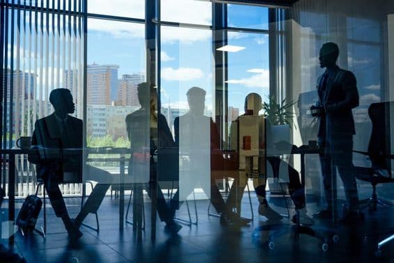 Executivos de negócios conversando com parceiros árabes e um colega.