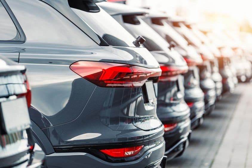 Vista traseira de muitos carros SUV modernos novos em um estacionamento.