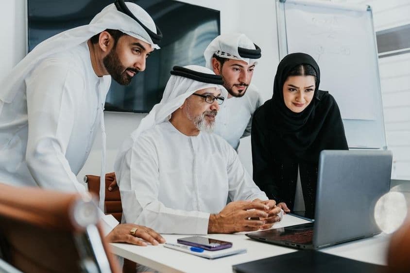 Um grupo de empresários do Oriente Médio em trajes tradicionais Emirati.