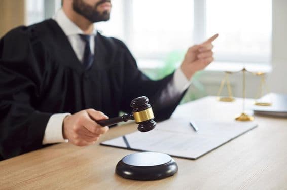 O juiz bate o martelo e o tribunal entrega a sentença na sala de audiências.