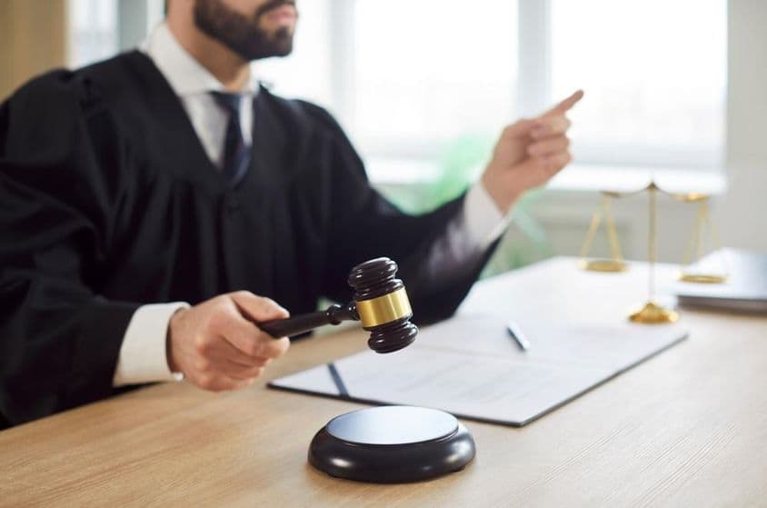 O juiz bate o martelo e o tribunal entrega a sentença na sala de audiências.