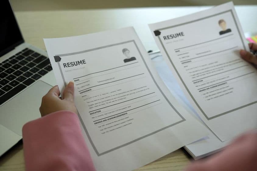 Uma jovem gerente de RH asiática lendo um currículo.