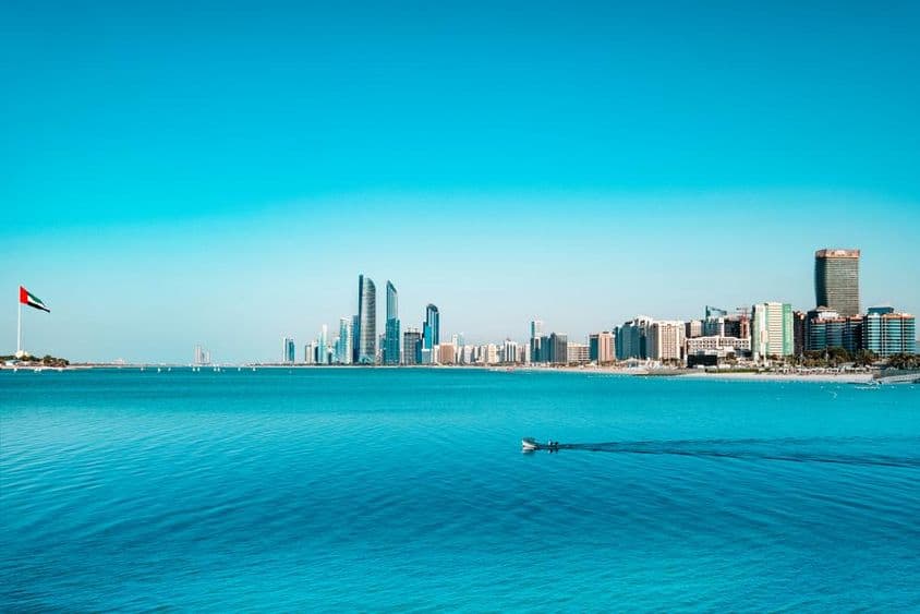 Vista da área à beira-mar de Abu Dhabi com um barco de pesca ao atravessar.