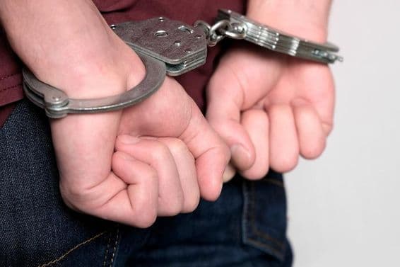 Um criminoso algemado preso por crimes.