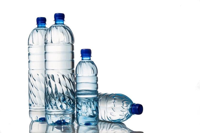 Quatro refrescantes garrafas plásticas de água mineral natural.