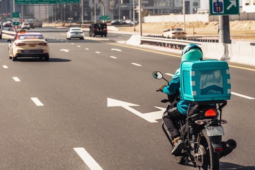 Dubai, homem em motocicleta para entrega de comida online.