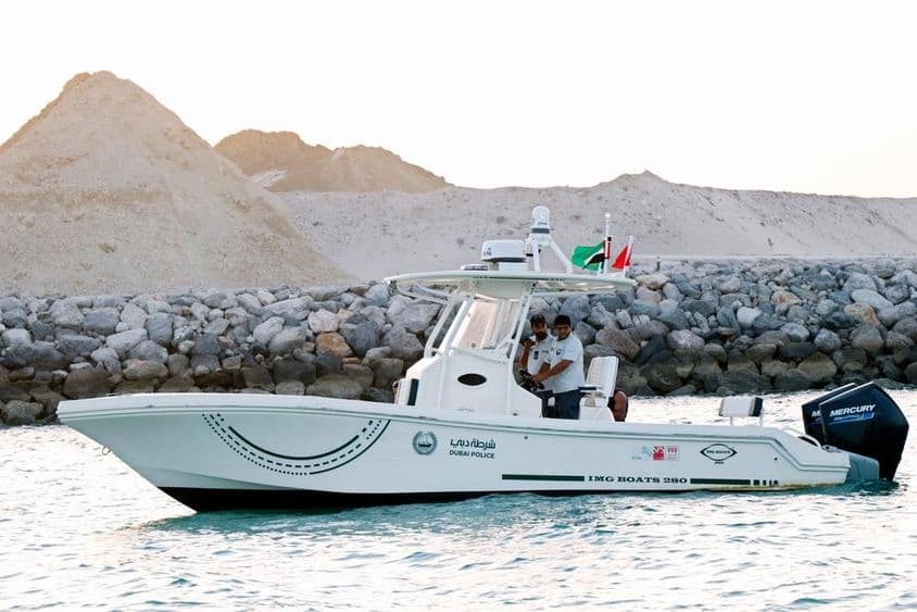 Policiais em um barco a motor ao longo da costa de Dubai.