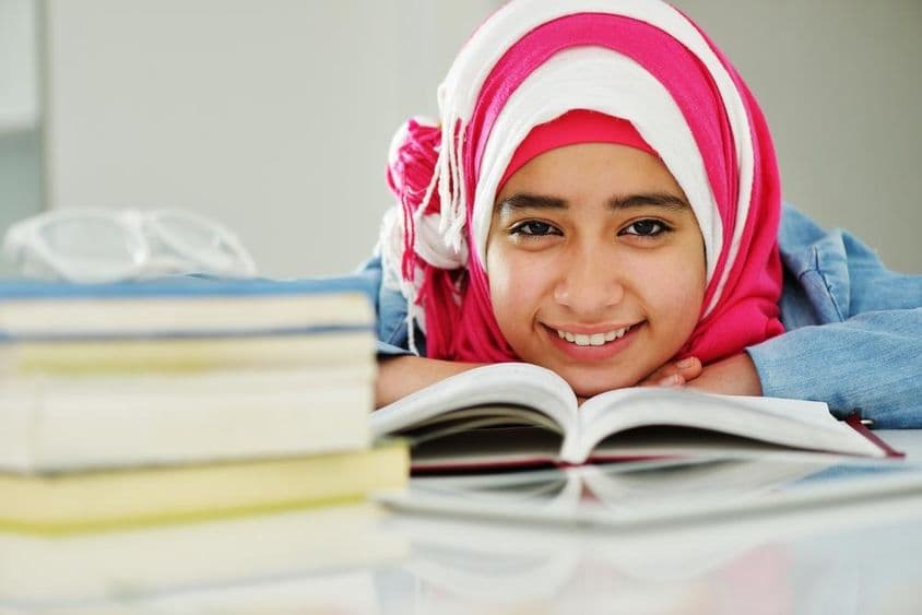 Linda menina muçulmana árabe lendo na faculdade.