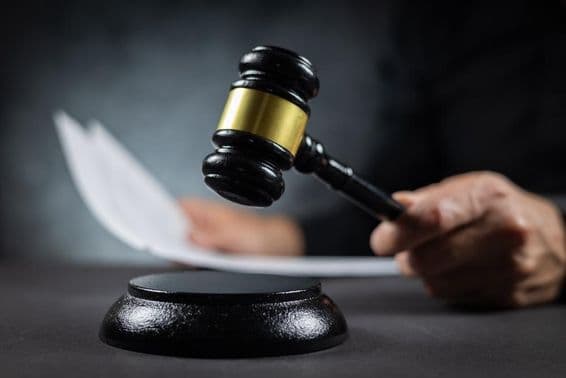 Juiz com martelo pronunciando julgamento no tribunal.