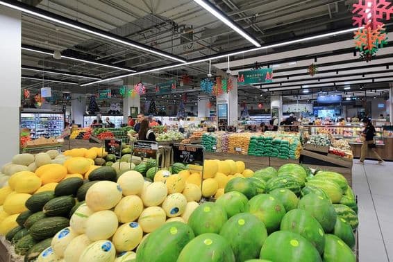 Melões verdes e amarelos empilhados para venda a consumidores em um supermercado no shopping de Dubai.