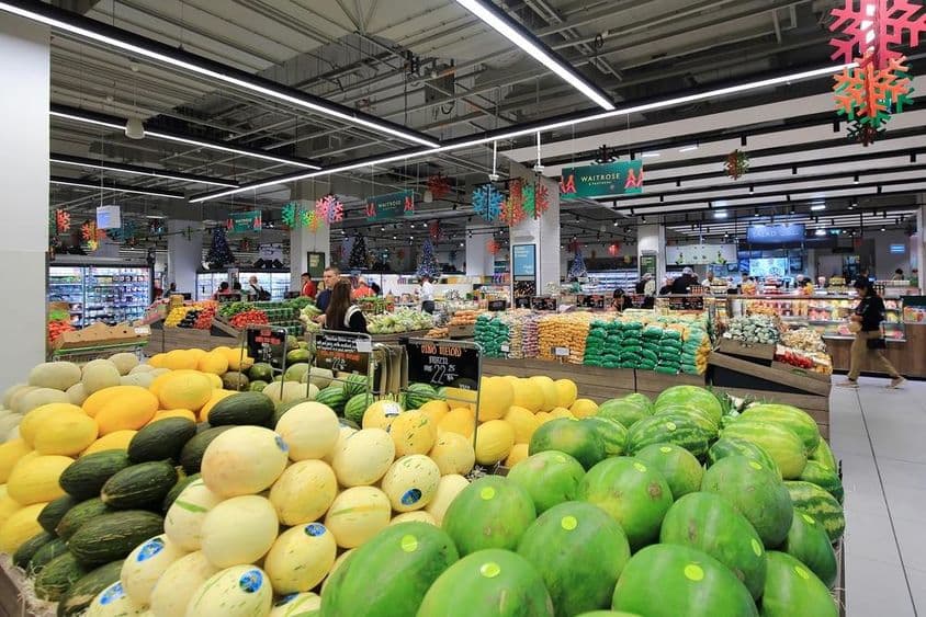 Melões verdes e amarelos empilhados para venda a consumidores em um supermercado no shopping de Dubai.
