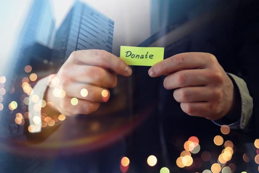 Empresário mostrando um documento com a palavra 'doação'.